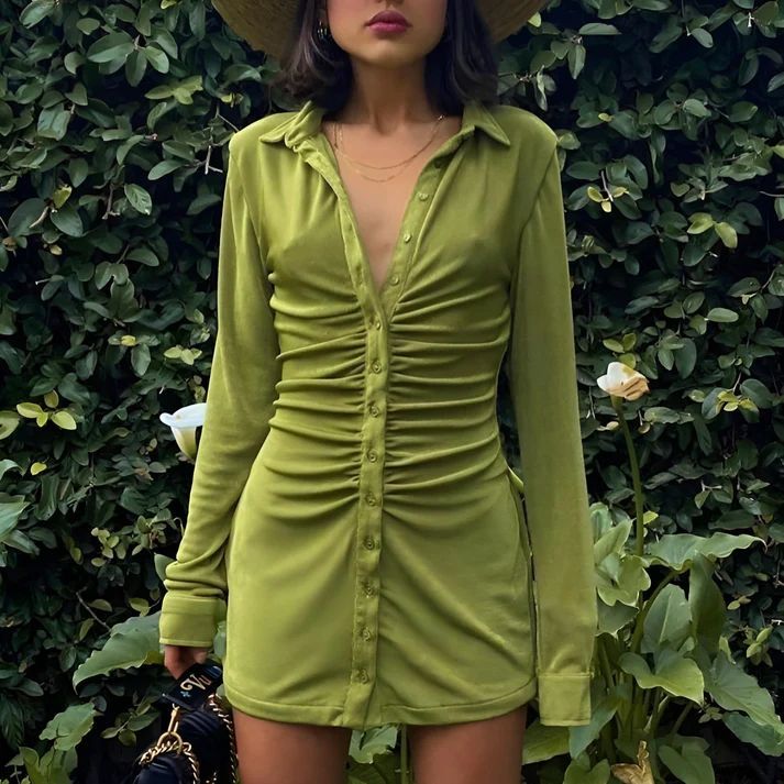 a woman wearing a green dress and hat