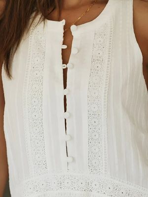 a close up of a woman wearing a white top