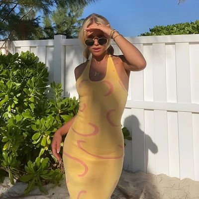 a woman in a yellow dress and sunglasses