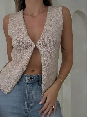 a woman wearing a tan sweater and jeans