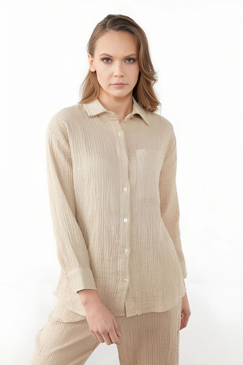 a woman wearing a beige shirt and pants