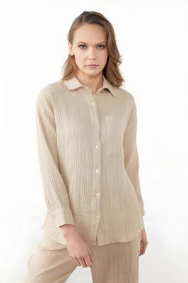 a woman wearing a beige shirt and pants