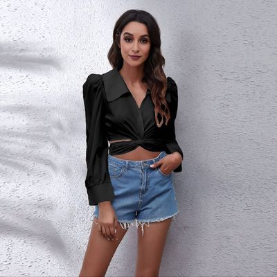 a woman wearing a black shirt and denim shorts