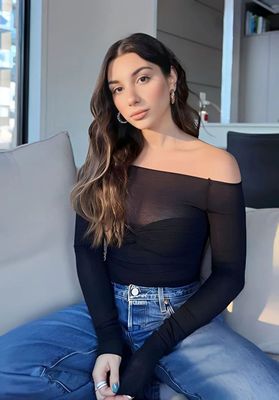 a woman sitting on a couch wearing a black top