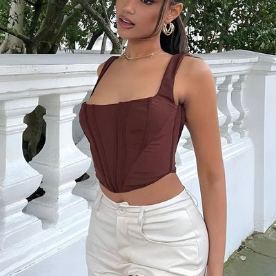 a woman wearing white pants and a brown top