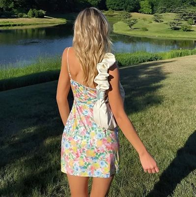 a woman in a colorful dress walking in the grass