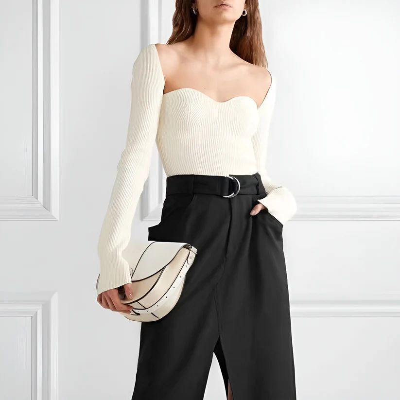 a woman wearing a white sweater and black pants