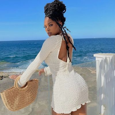 a woman in a white dress standing on the beach