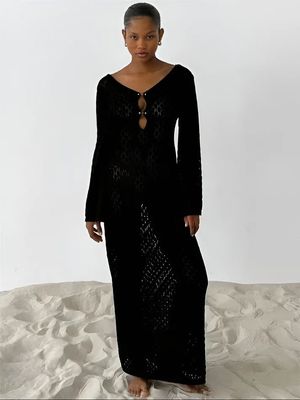 a woman in a black dress standing on a white surface