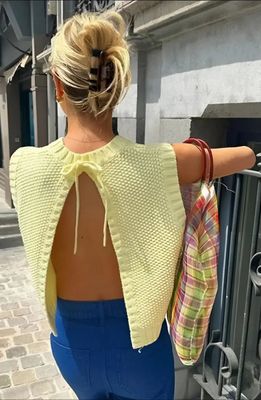 a woman wearing a yellow sweater and blue pants