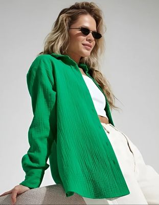 a woman wearing a green jacket and white pants
