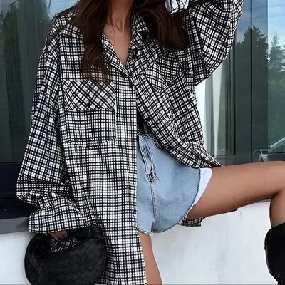 a woman in a plaid shirt and denim shorts
