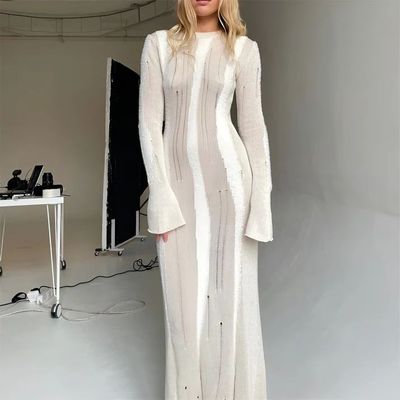 a woman in a white dress standing in front of a tv