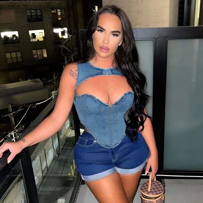 a woman in a denim corset holding a purse