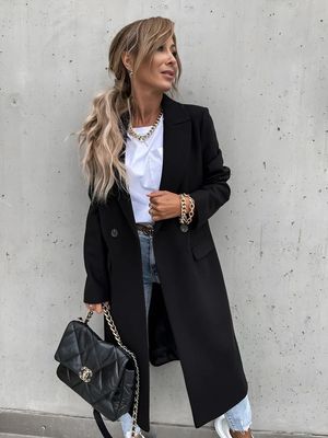 a woman wearing a black coat and jeans