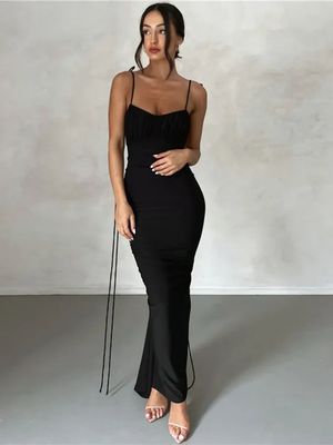 a woman in a black dress posing for a picture