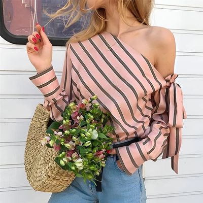 a woman holding a bouquet of flowers and a straw bag
