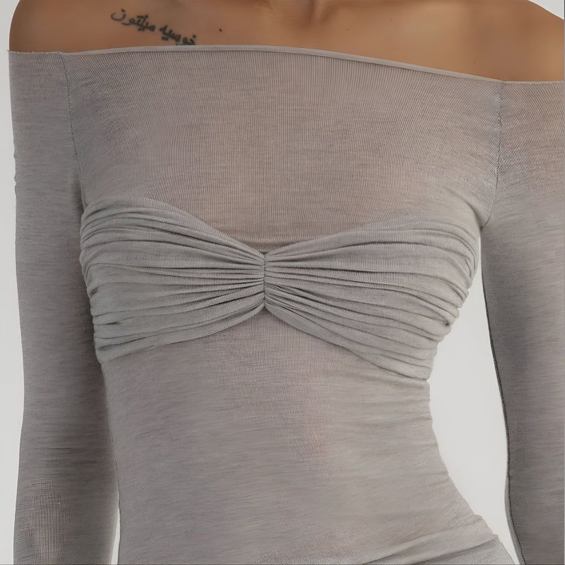 a woman with a tattoo on her arm wearing a gray top