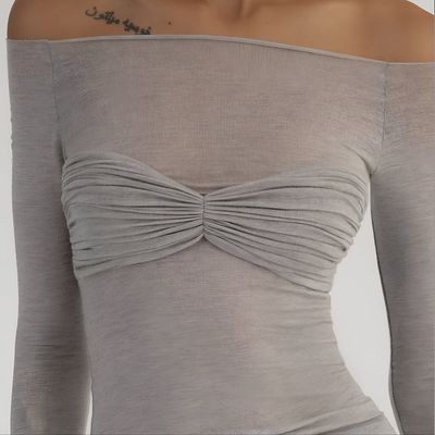 a woman with a tattoo on her arm wearing a gray top