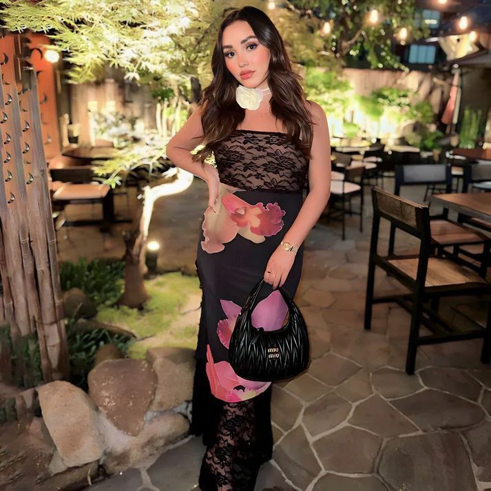 a woman in a black dress holding a purse