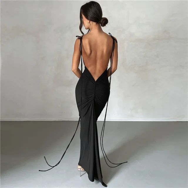 a woman in a black dress with a backless top