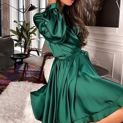 a woman in a green dress posing for a picture