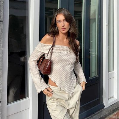 a woman is walking down the street with her hand on her hip