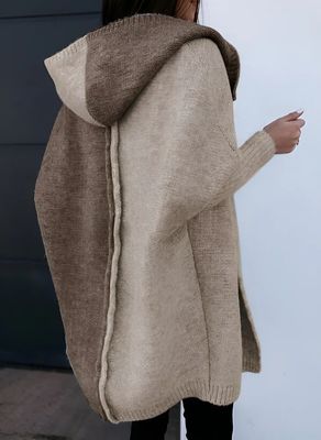 a woman wearing a sweater and black pants