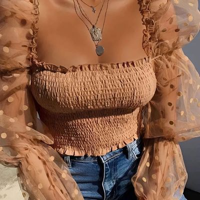 a woman wearing a brown top and jeans