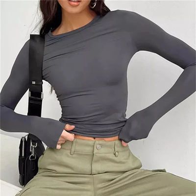 a woman wearing a gray top and khaki pants