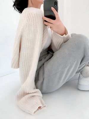 a woman sitting on the ground holding a cell phone