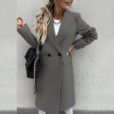 a woman standing against a wall with her hands on her hips