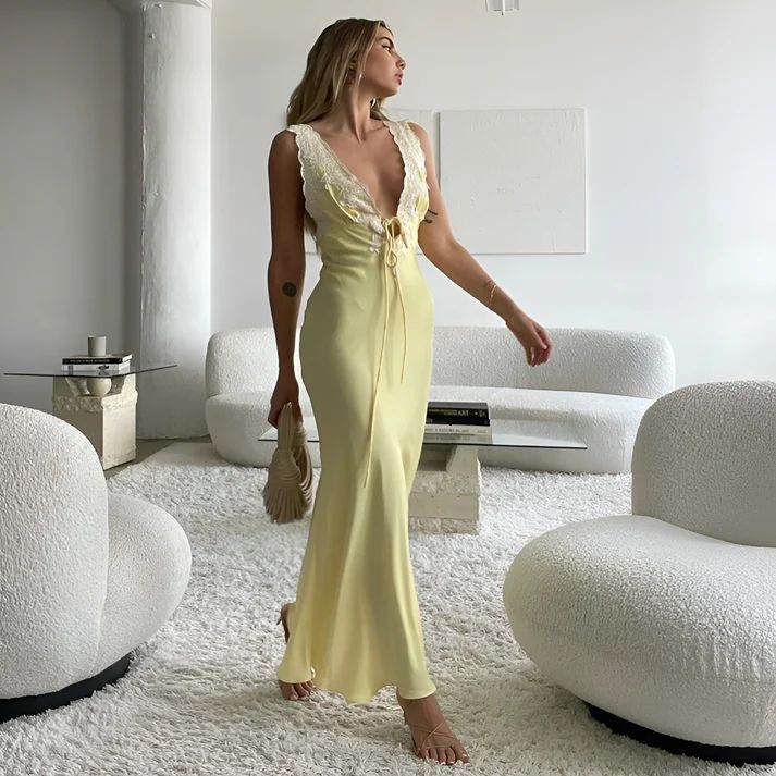 a woman in a yellow dress standing in a white room
