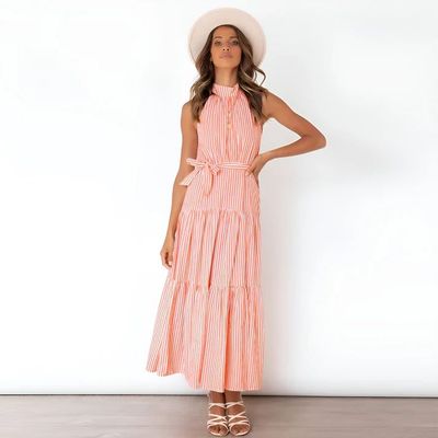 a woman in a dress and hat poses for a picture