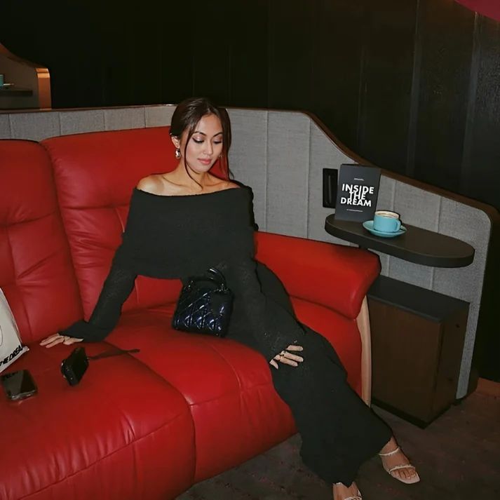 a woman sitting on a red couch in a room