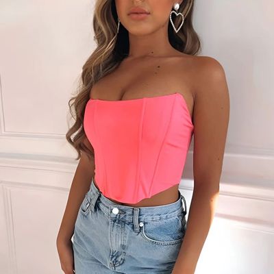 a woman wearing a pink top and denim shorts
