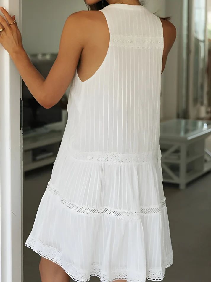 a woman in a white dress is looking at herself in the mirror