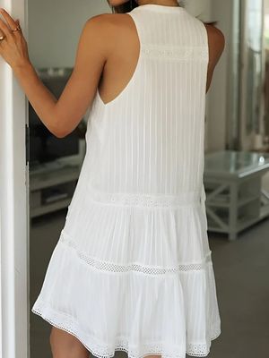 a woman in a white dress is looking at herself in the mirror