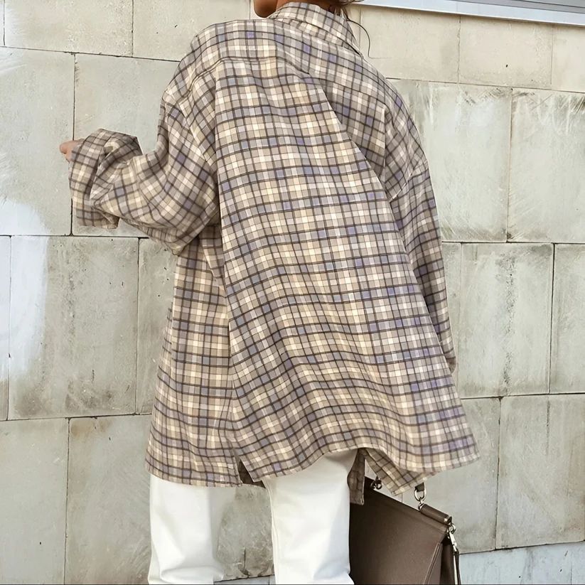 a woman is standing against a wall with a handbag