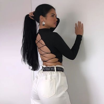 a woman wearing white pants and a black top
