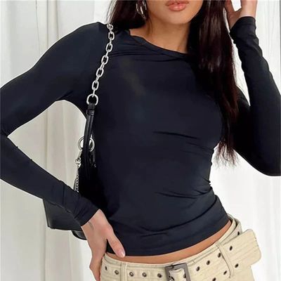 a woman wearing a black top and tan pants