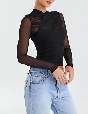 a woman wearing a black top with sheer sleeves