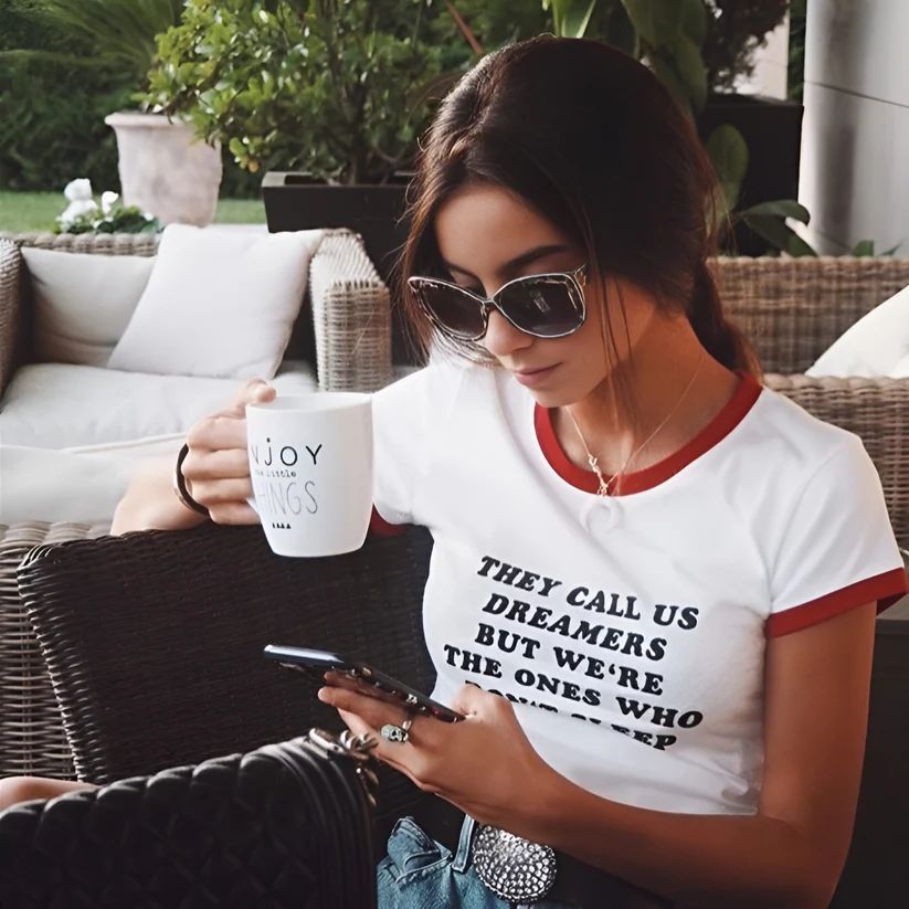 a woman sitting on a couch using a cell phone
