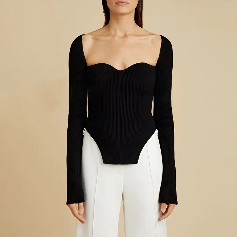 a woman wearing a black top and white pants