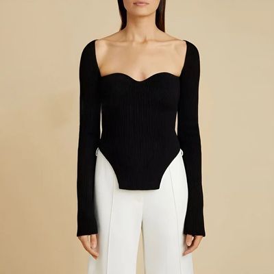 a woman wearing a black top and white pants