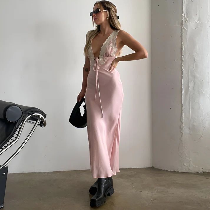 a woman in a pink dress standing next to a motorcycle