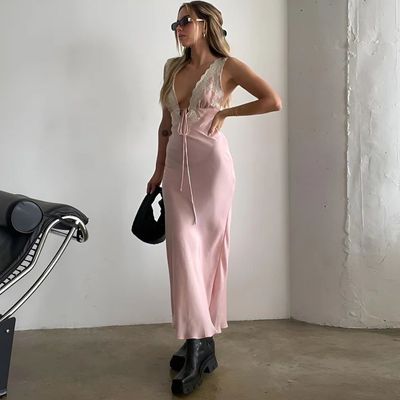 a woman in a pink dress standing next to a motorcycle