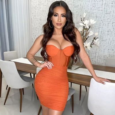 a woman in an orange dress posing for a picture