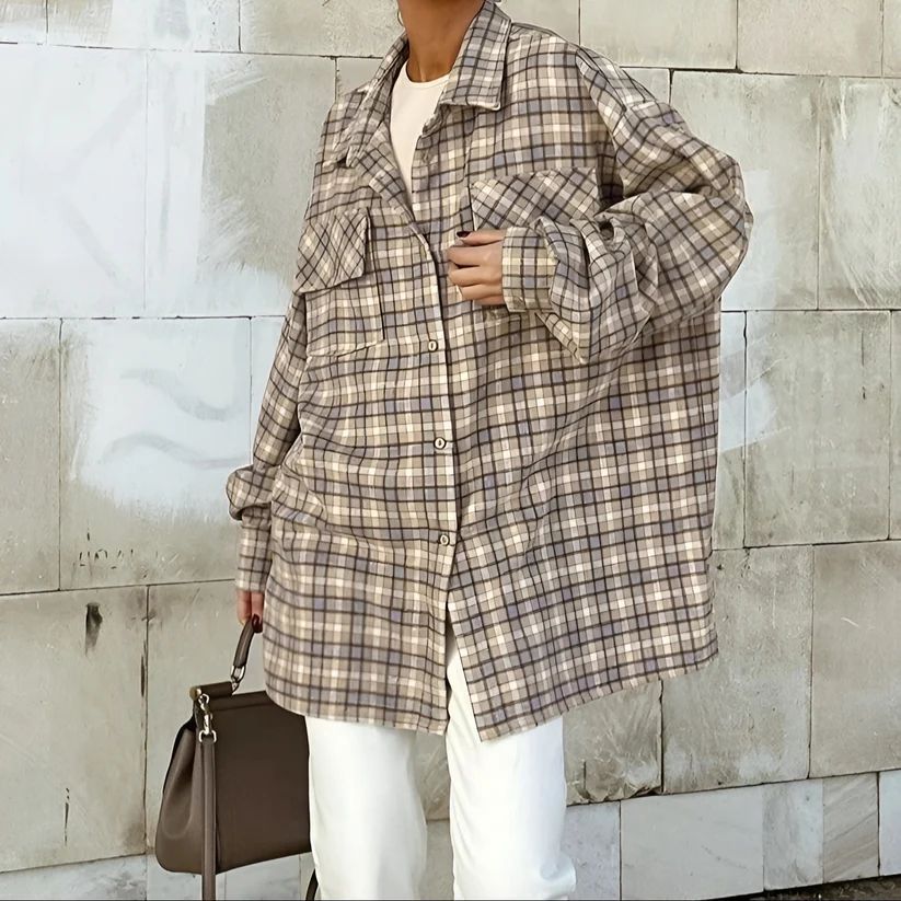 a woman standing in front of a wall holding a handbag