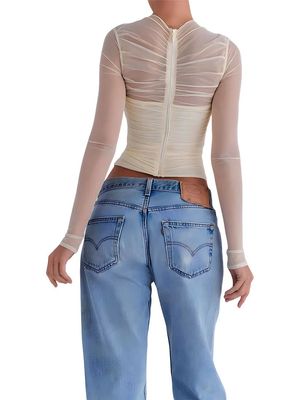 a woman wearing a white top and jeans